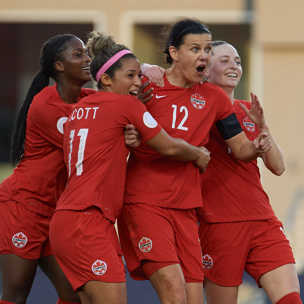 Canada Soccer women's team hugging and celebrating