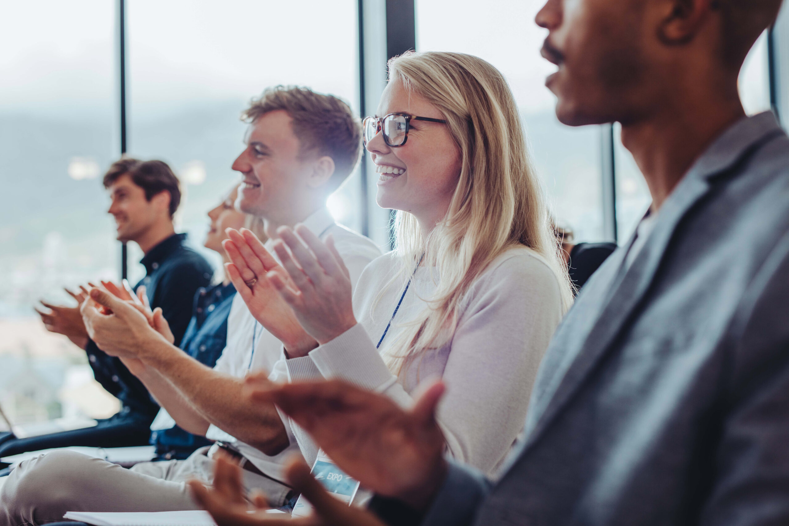 Young professionals clapping at a conference