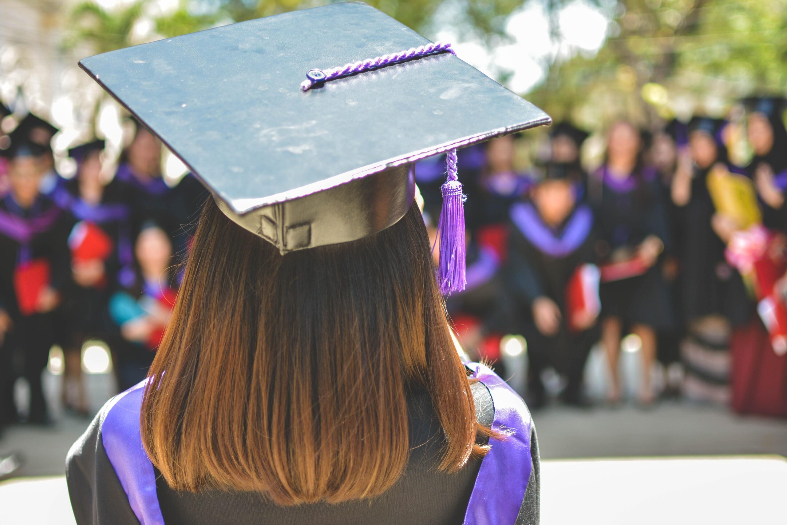 Shot of the back of a woman's head, wearing a graduation cap and gown