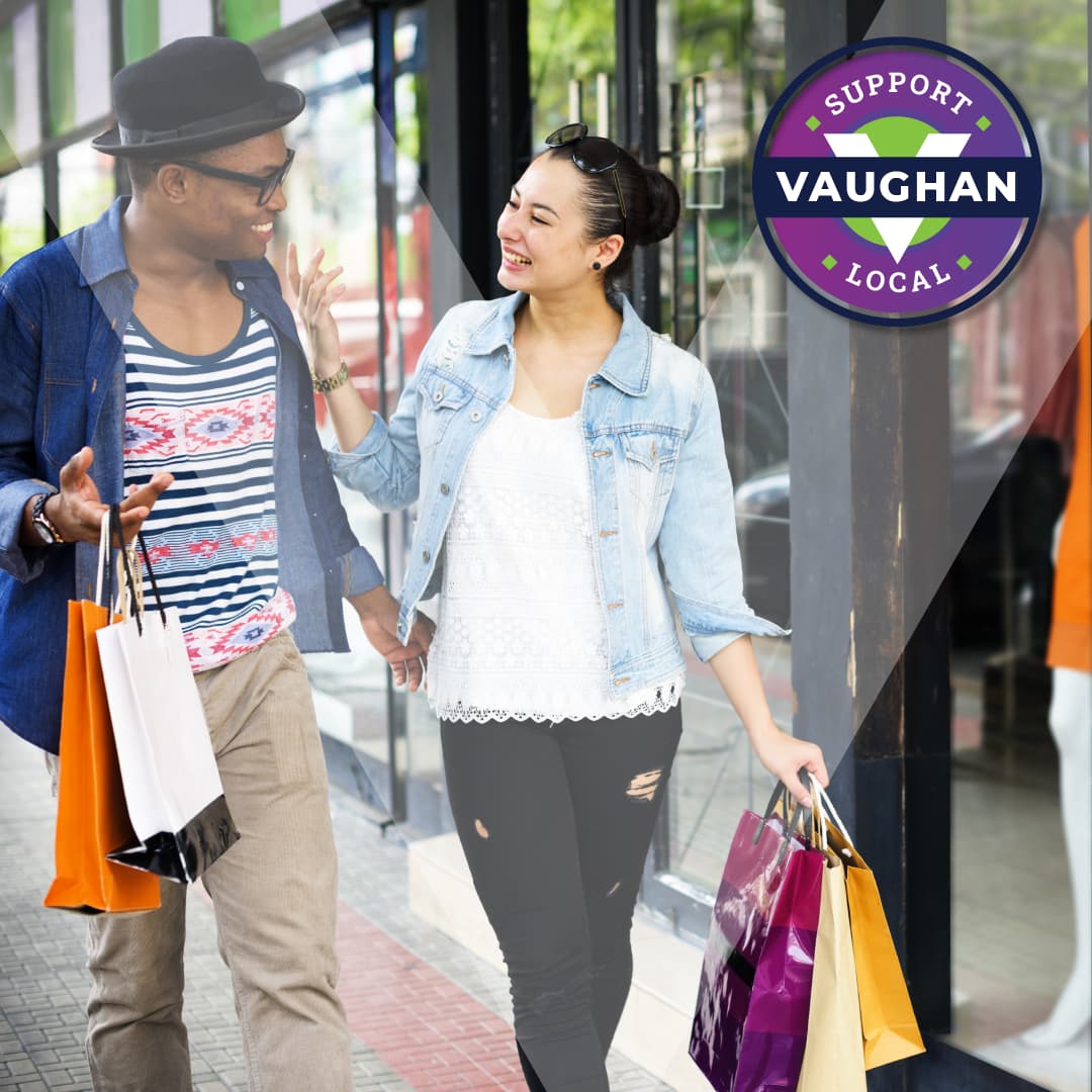 A young male and female walking with shopping bags.