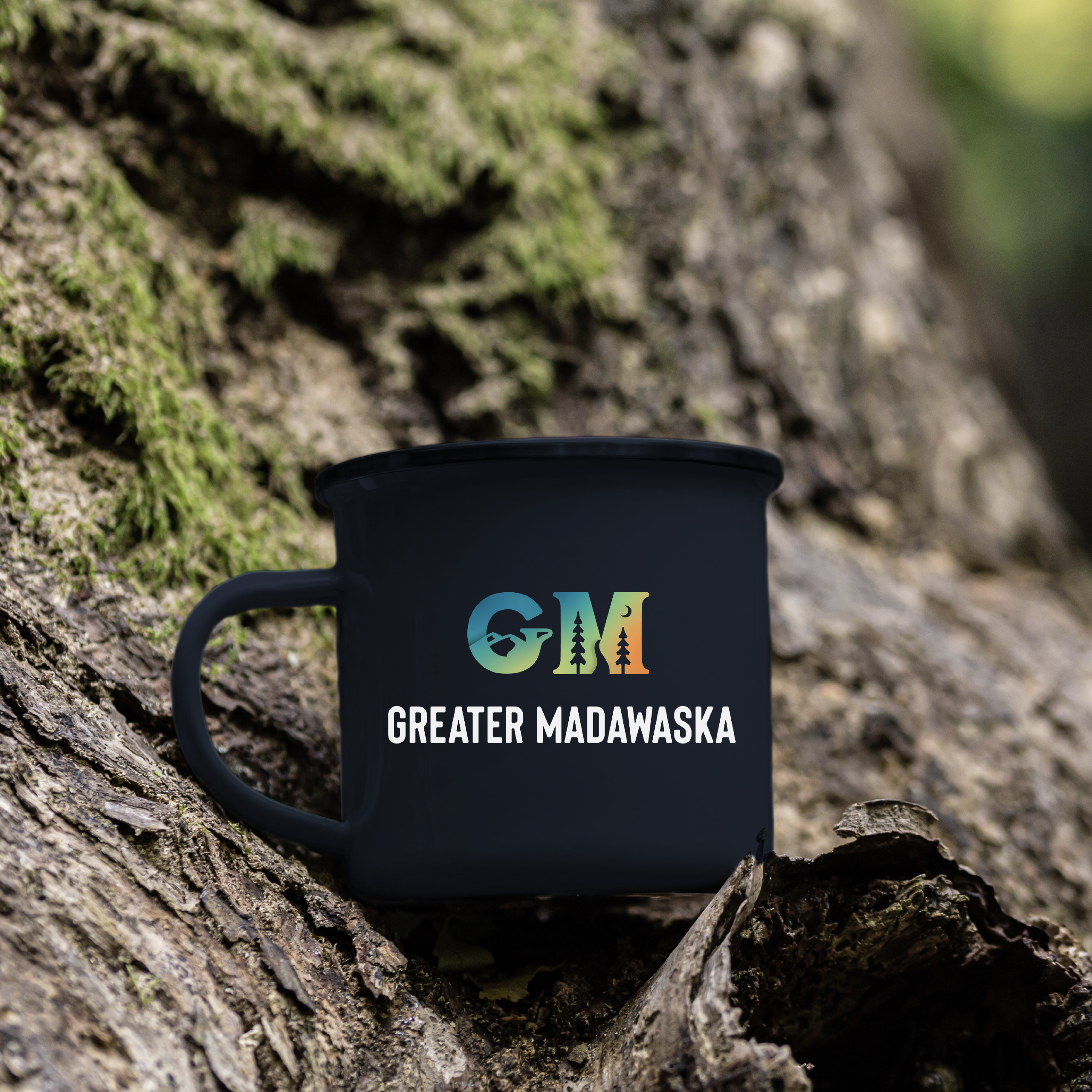 Greater Madawaska logo mock up on a coffee mug sitting on a tree root