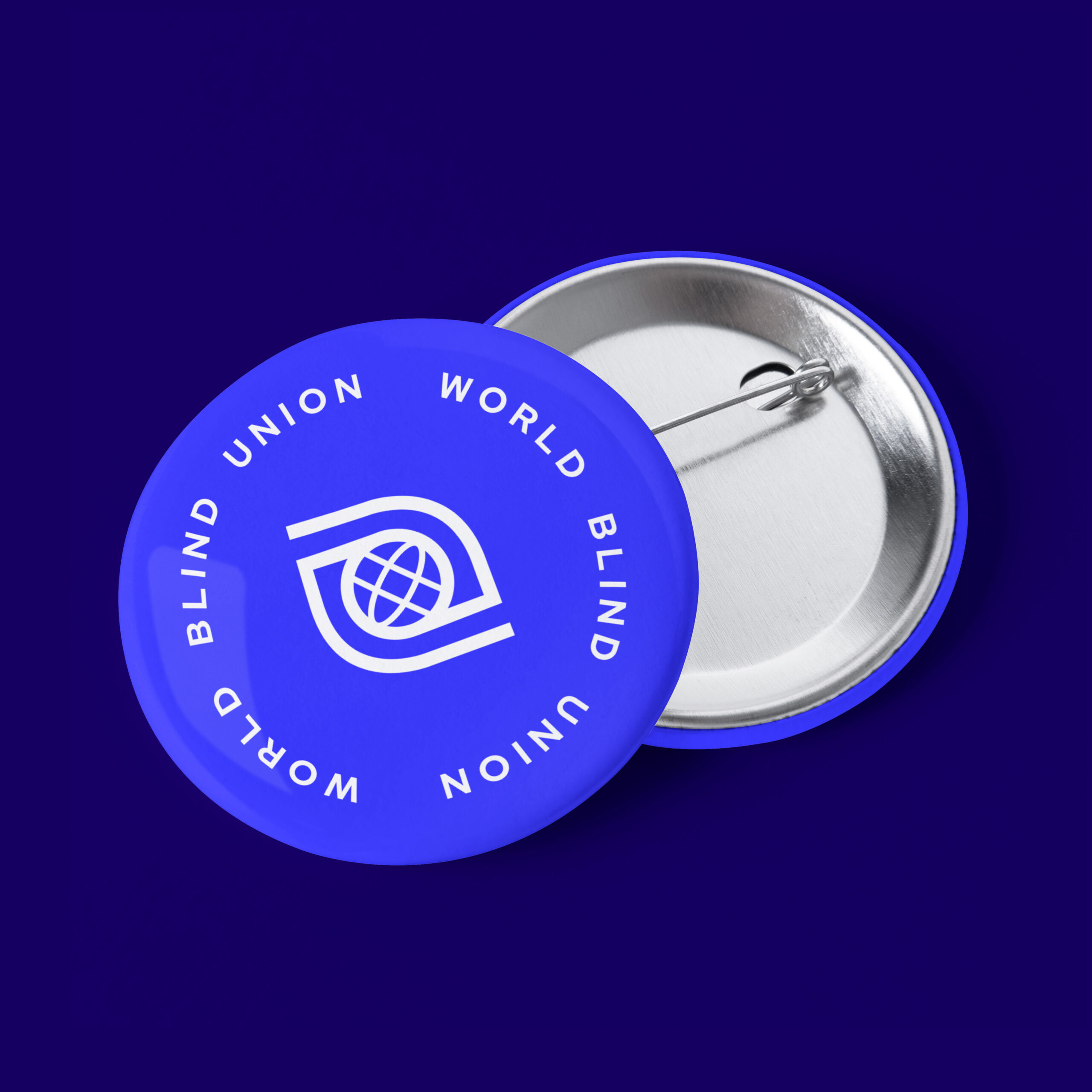 Two blue pin-back badges with "World Blind Union" text and logo on a dark blue background.
