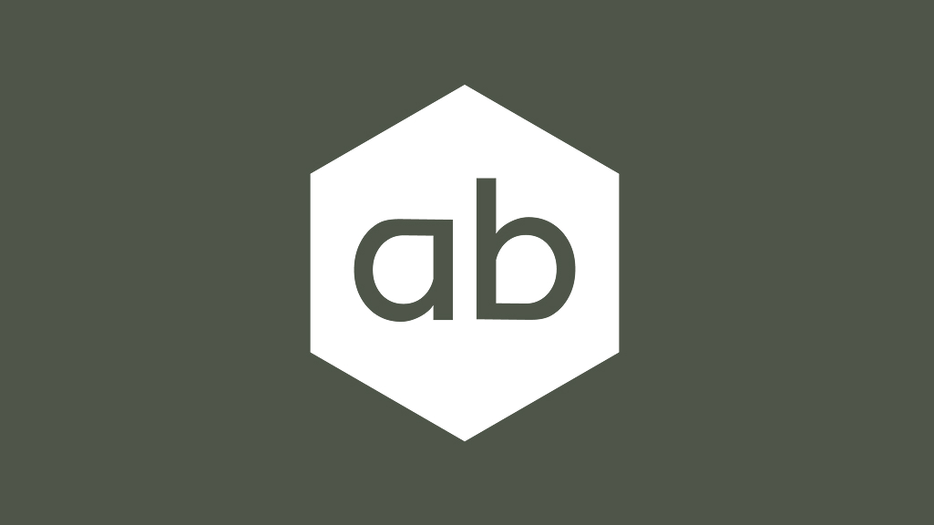 A white hexagon with the lowercase letters “ab” in dark grey centred on a dark grey background.