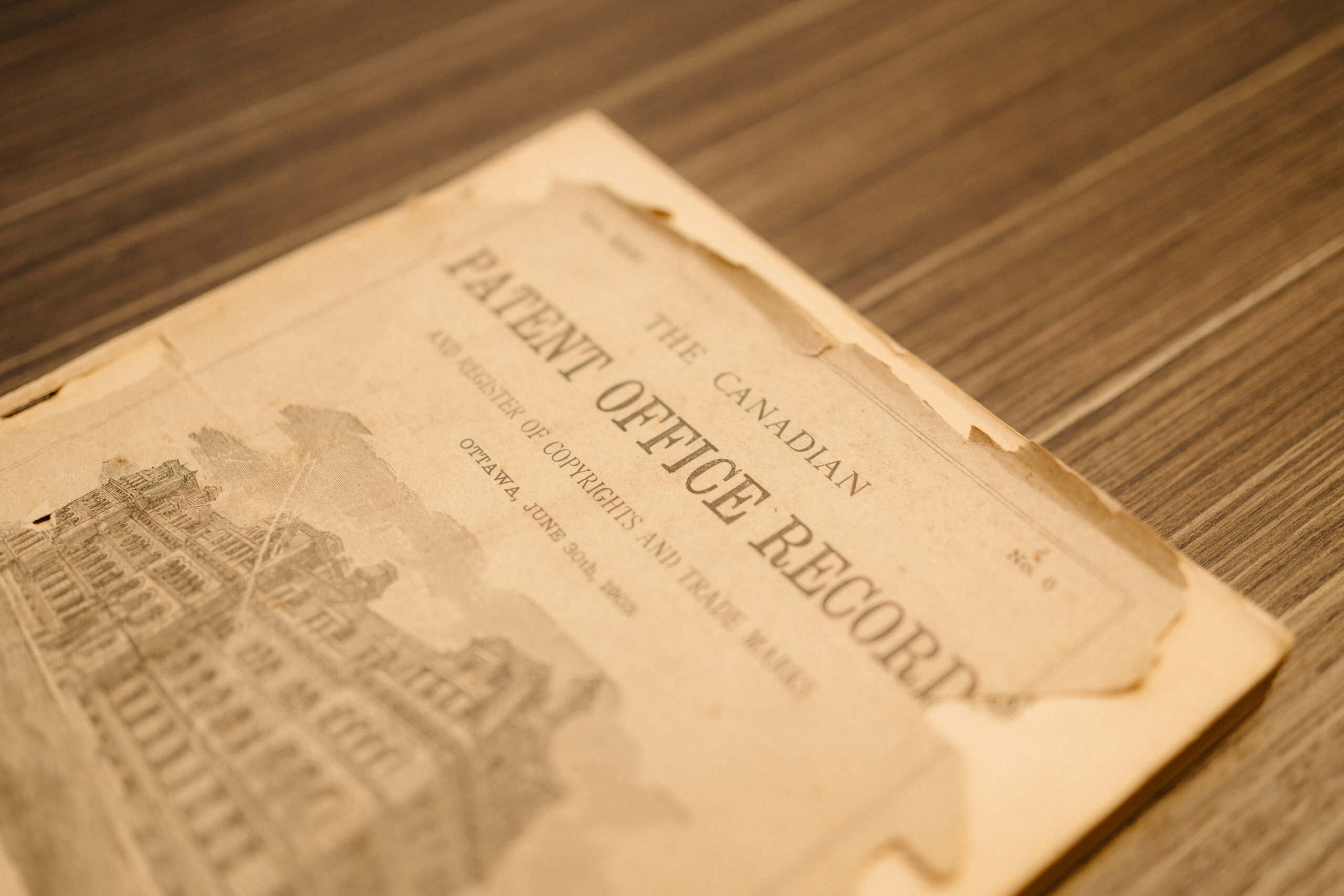 A worn copy of The Canadian Patent Office Record rests on a wooden surface.